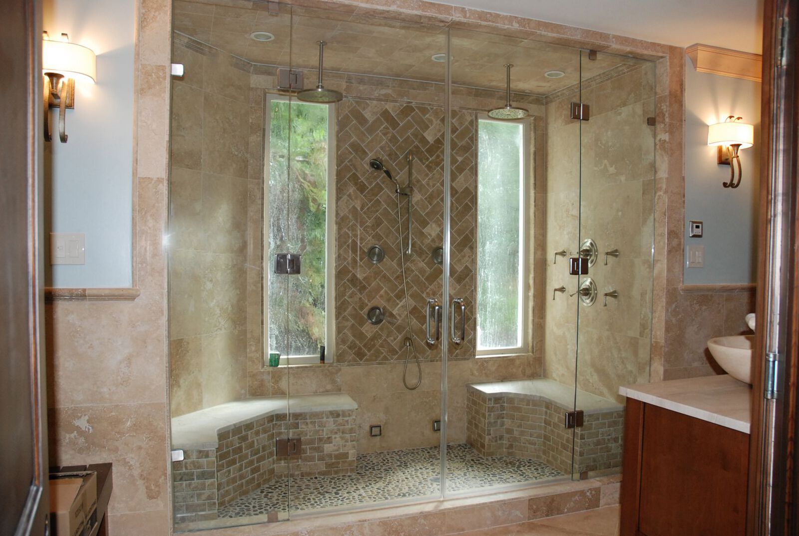 Giant Steam Shower. This enclosure has French doors that are supported by flanking glass panels. Each door is hinged off adjacent glass panels using glass to glass hinges. Panels are physically fastened into walls using 2"x2" metal glass clamps.