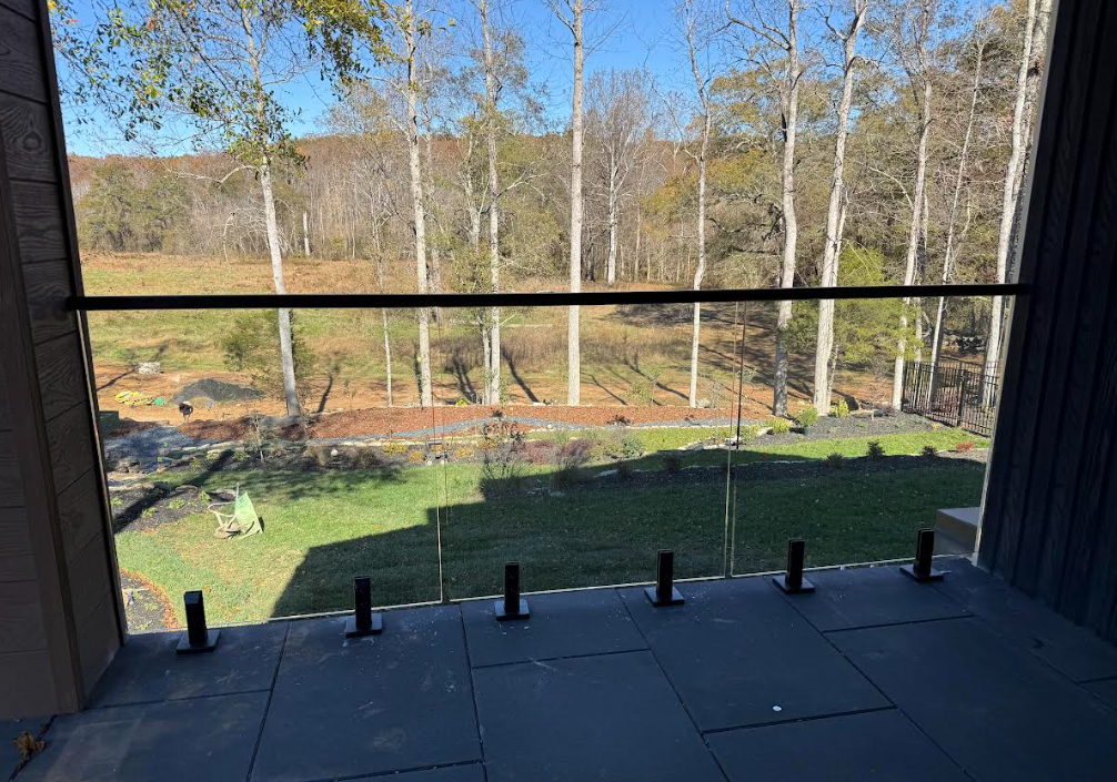 This front porch has a stunning view which is elevated by the glass railings. We've included laminated glass and a top rail for safety while maintaining a seamless appearance with spigots on the bottom.